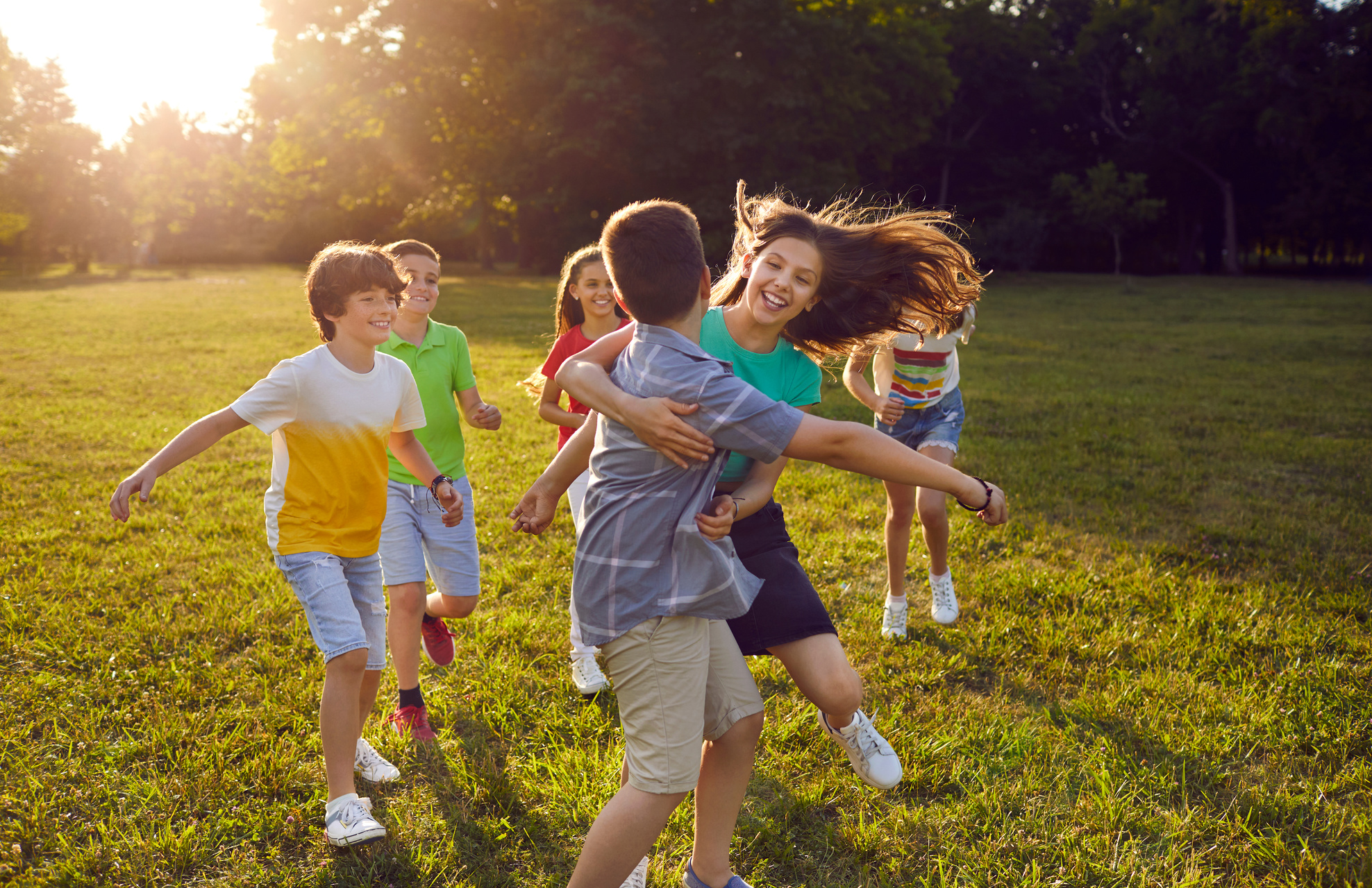 Group of Happy, Cheerful Kids Enjoying Summer Vacation and Playing Tag in the Park